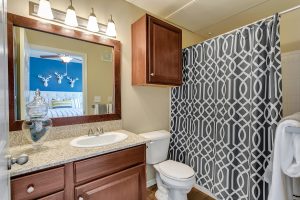 Bathroom with large mirror, one sink, tub and ample cabinets